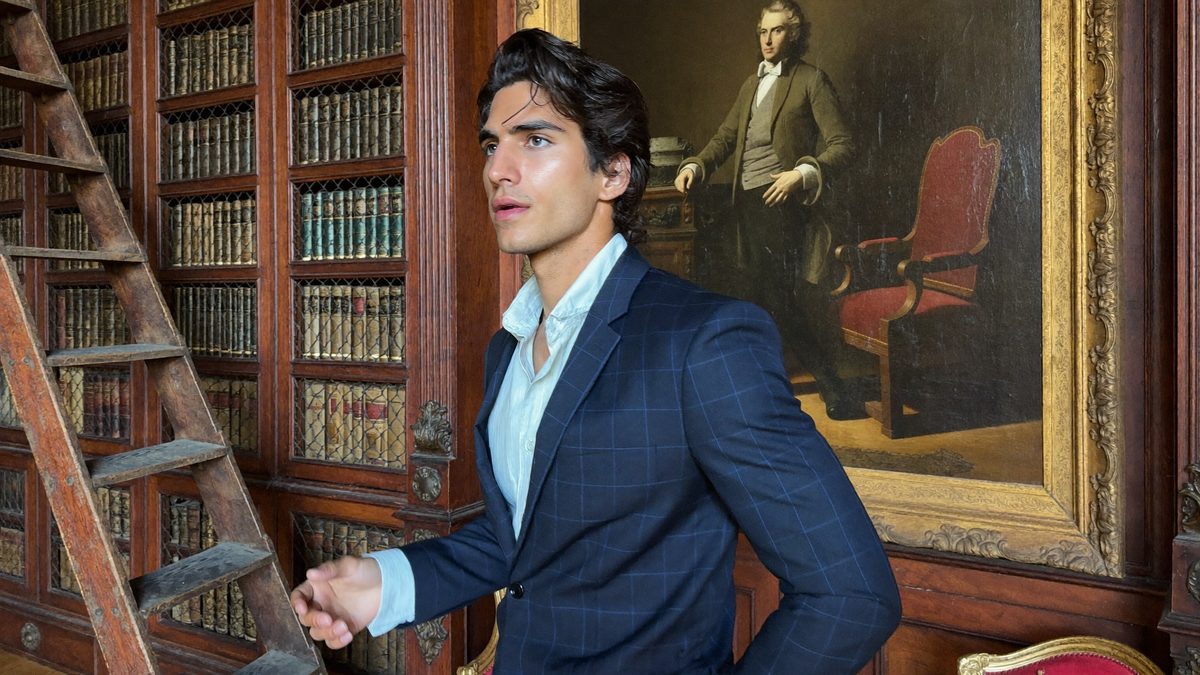 Man in a suit standing among bookshelves