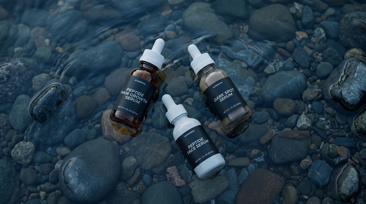 Three Acendsion peptide serum bottles on wet river stones